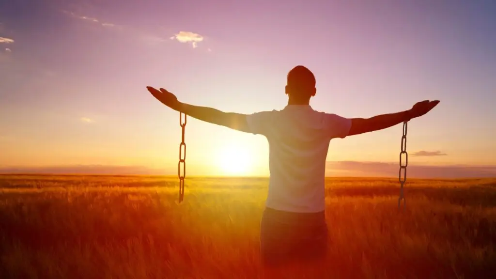 A man loosened from chains in a field illustrating freedom from secondary depression