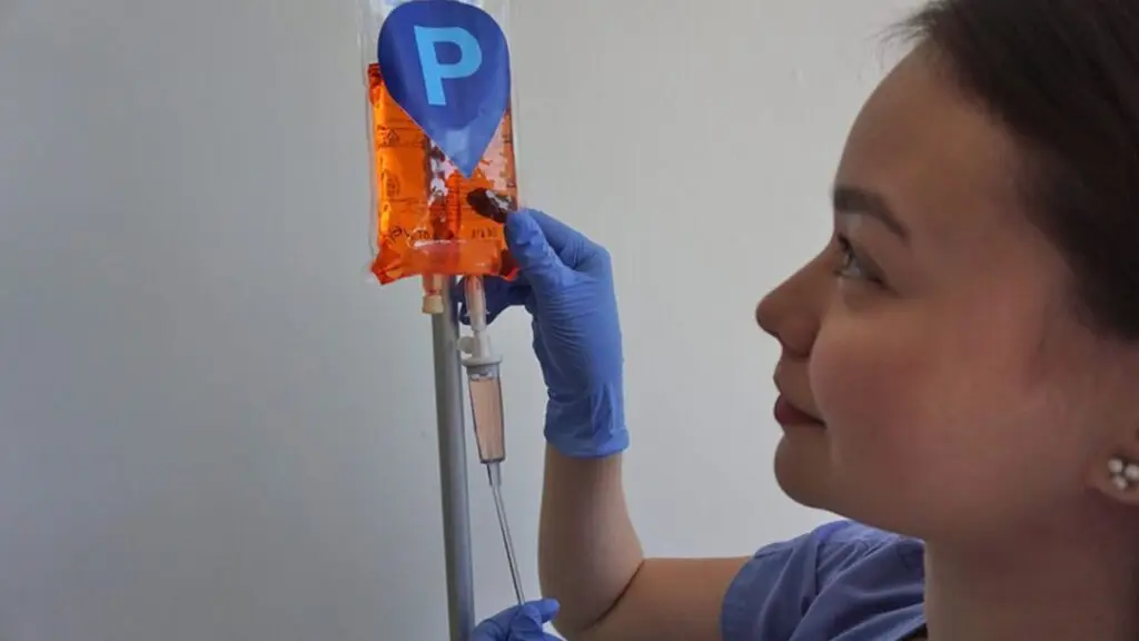 Image of nurse Nicole Catipon setting up an IV drip infusion bag