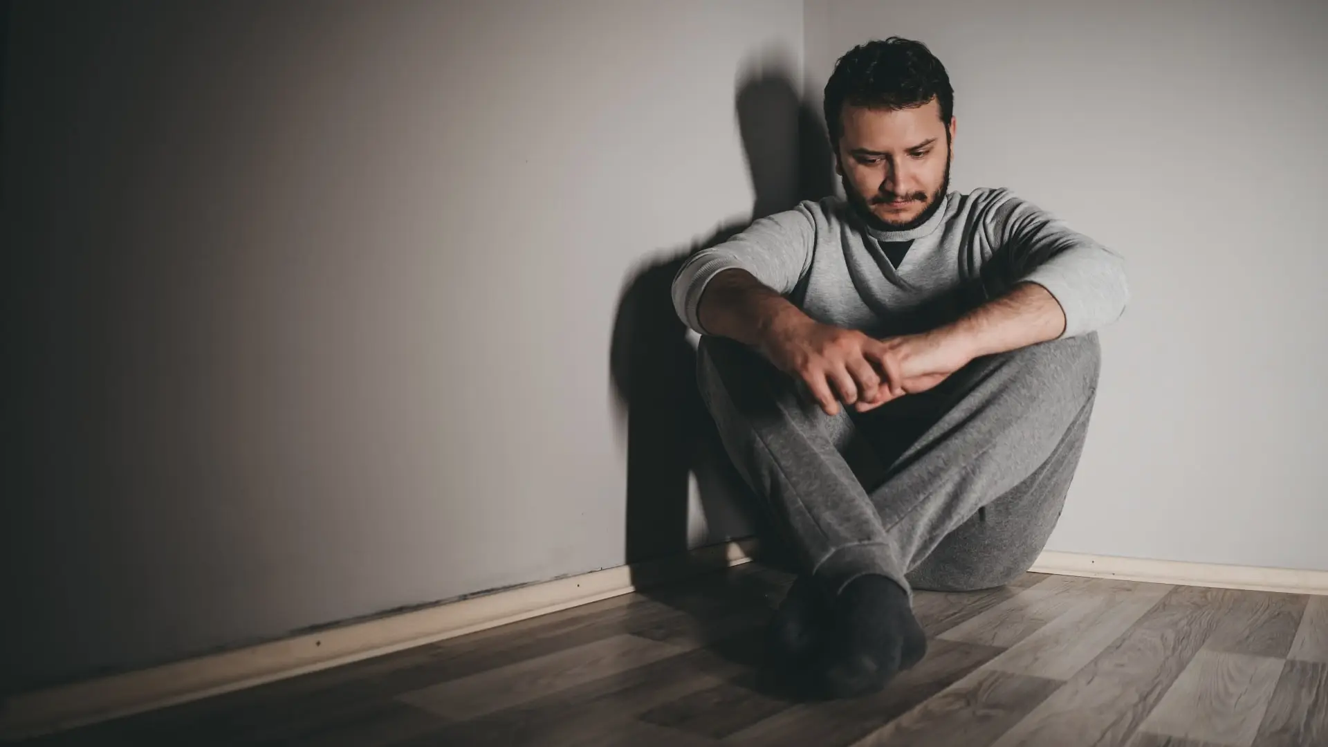 Man sitting in a dark corner due the feeling secondary depression caused by other ailments